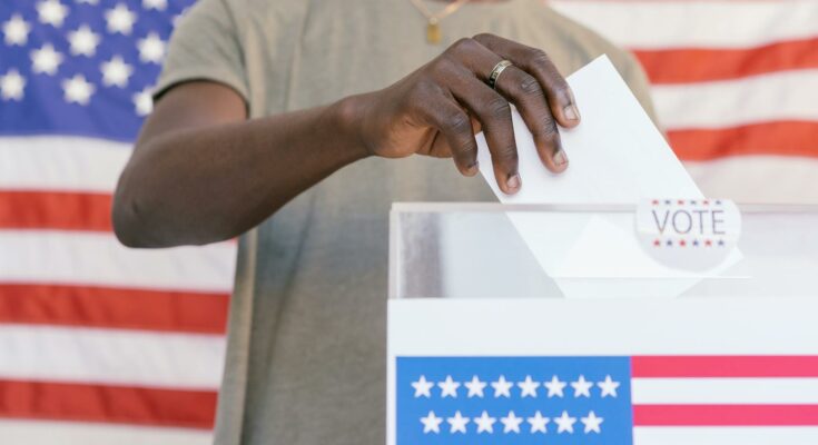 Person putting his vote on ballot box