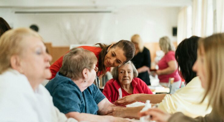 A caregiver talking to a group of seniors