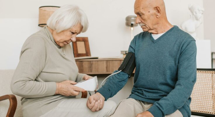 Woman checking blood pressure of a man