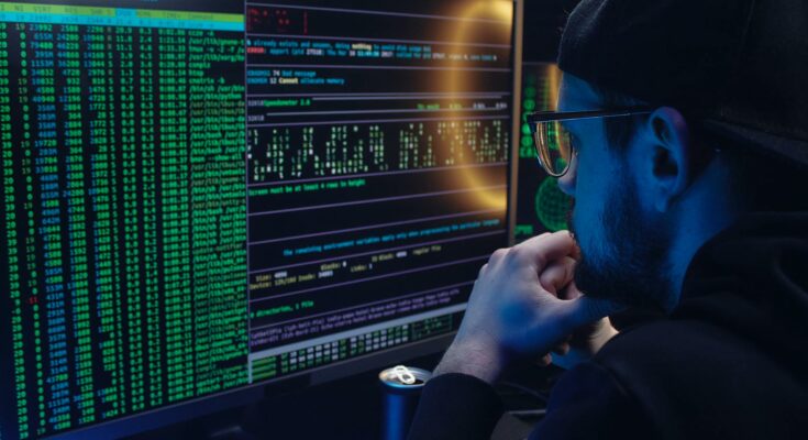 A man looking at a computer screen with data