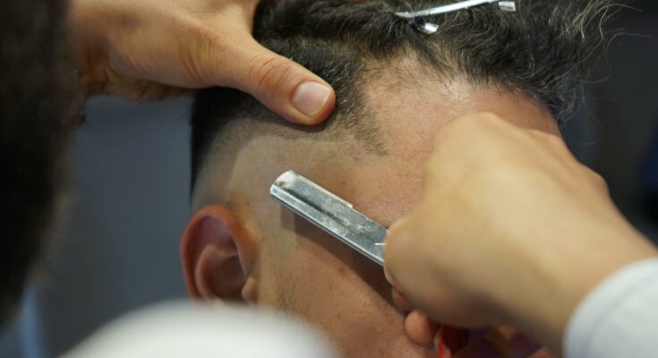 A barber using a razor blade
