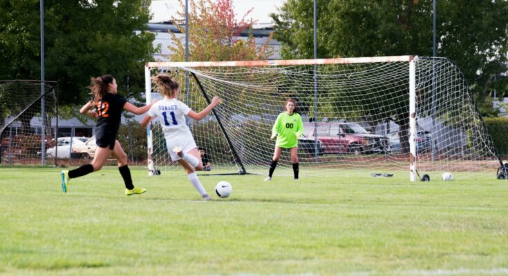 Three women playing soccer game