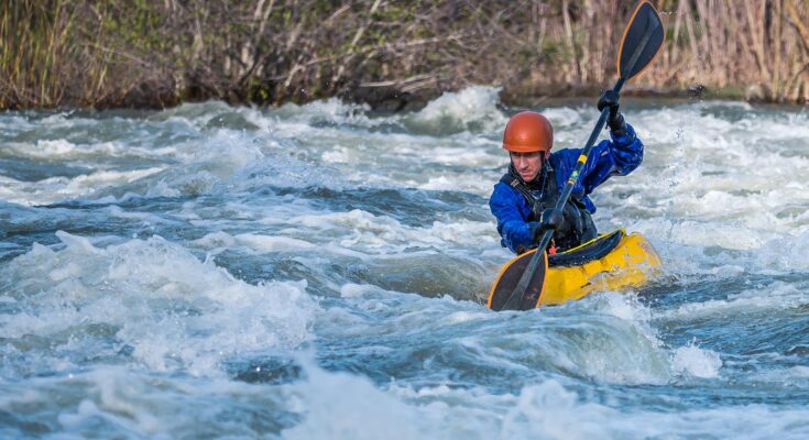 Man paddling kayak in raging river