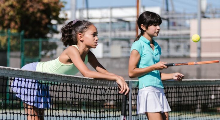 Girls standing by the tennis net