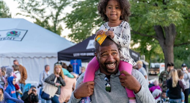 girl sitting on smiling man s shoulder