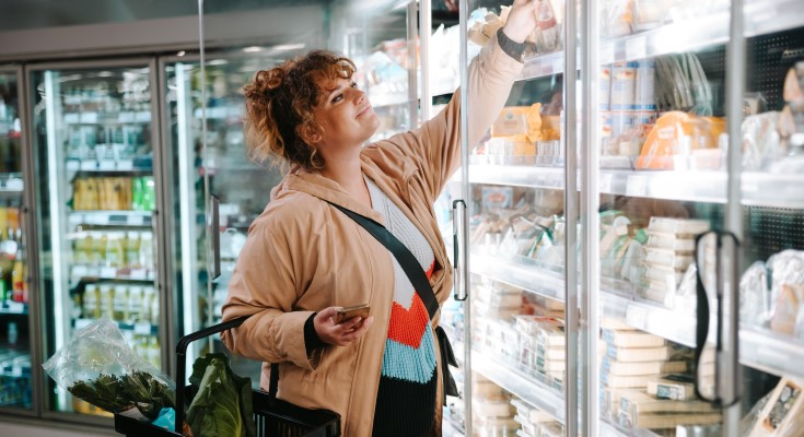 A woman shops the refrigerated dairy aisle