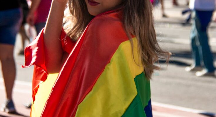 Woman holding rainbow coloured flag
