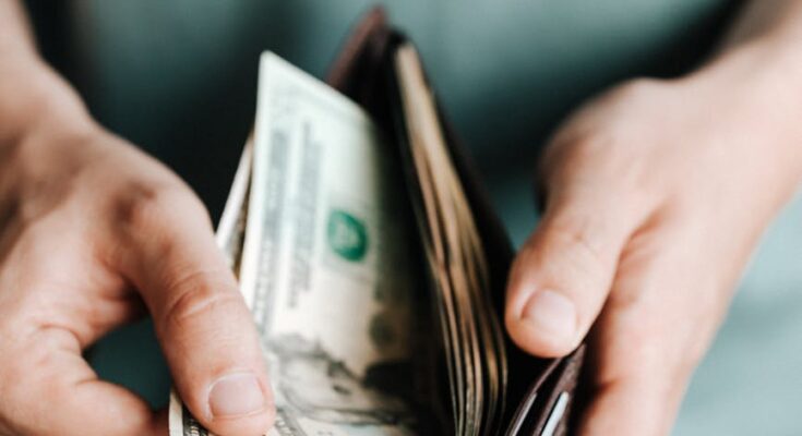 Man getting dollars from wallet