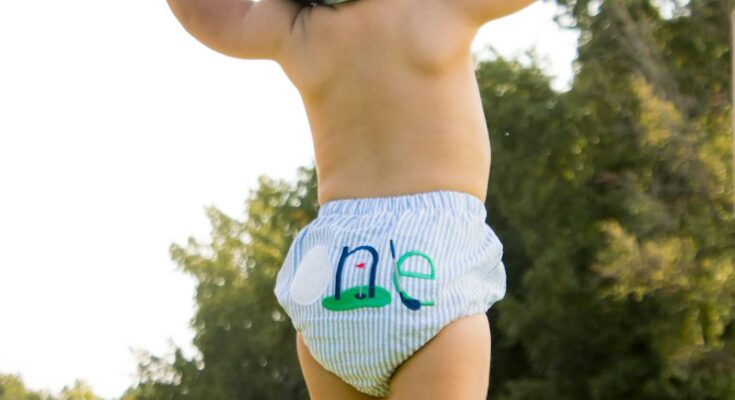 Baby first steps outdoors with parental support