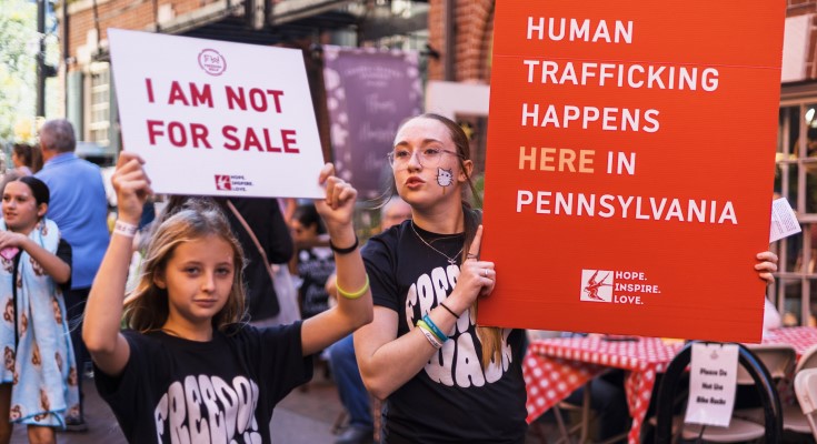 Two Freedom Walk attendees holding awareness signs