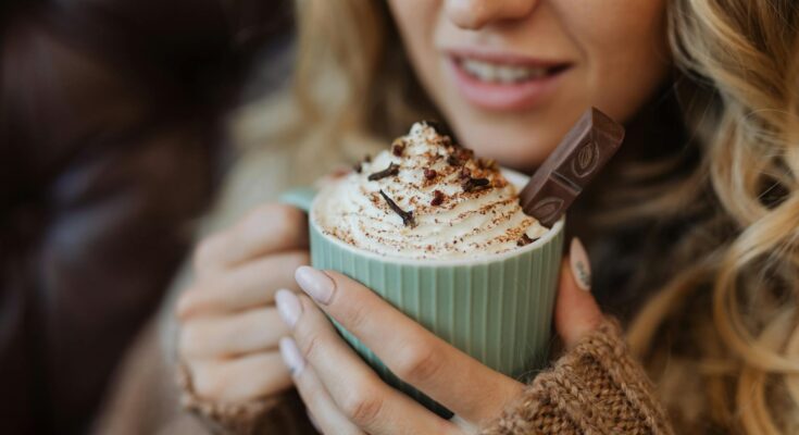 A woman holding a cup of hot cocoa