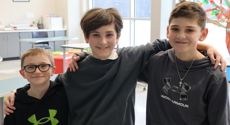 Former charter student Dimi (center) has settled into DASD, building friendships and finding his place at his new school