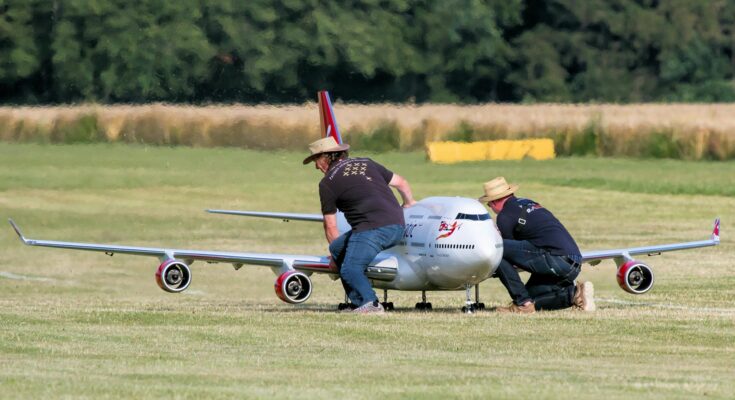 Men setting up a large flying model of an airliner