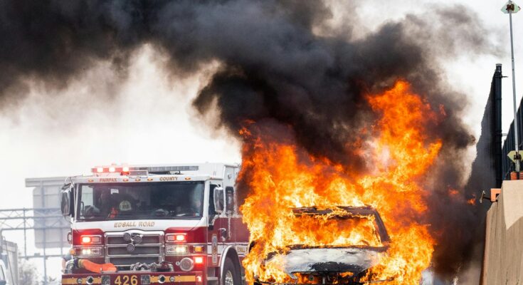 Firretruck next to burning car on street
