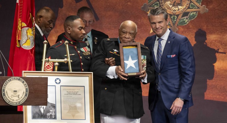 Secretary of War Pete Hegseth poses for a photo with retired Marine Corps Maj. James Capers Jr. during a Hall of Heroes induction ceremony at the Pentagon.