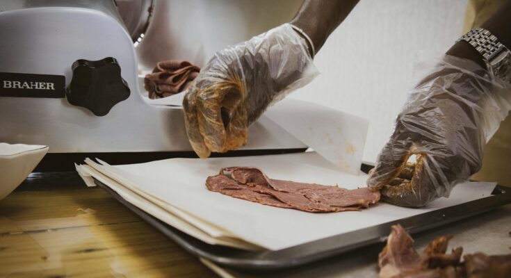 person slicing meat