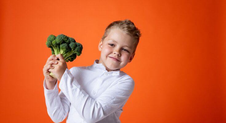 boy in white dress shirt holding green plant