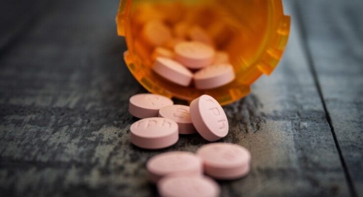 white medication pill on orange plastic container