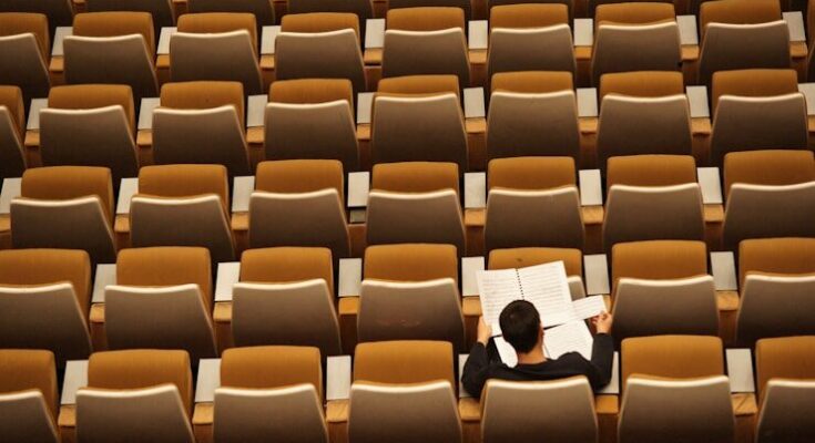 person reading in empty lecture hall