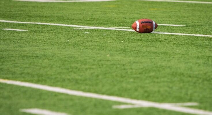 A football laying on a football field