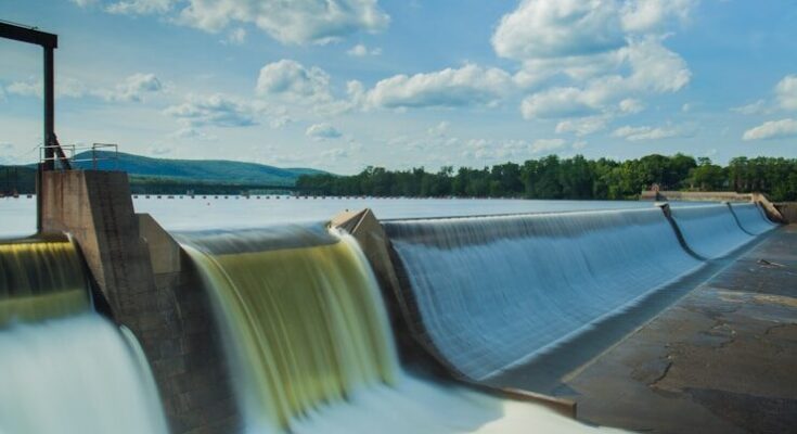 water dam under white and blue skies