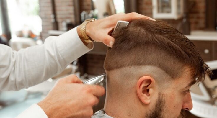man in white dress shirt cutting hair of man