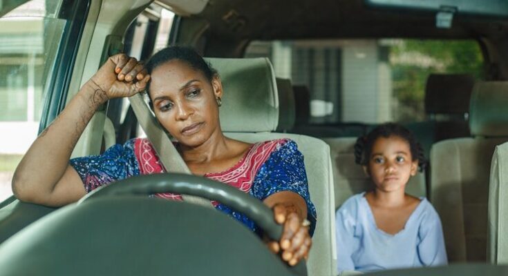 a woman and a child sitting in a car