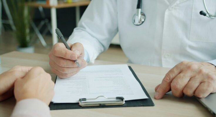 Doctor writing on a patient's chart