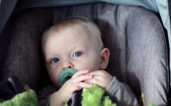 baby on gray stroller