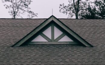 a roof with a triangle shaped window on top of it