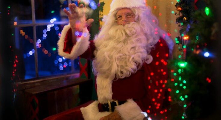 santa claus sitting beside lit tree
