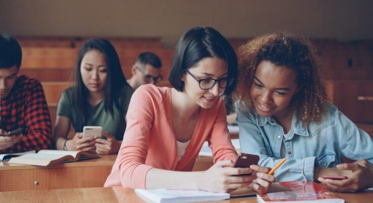 Students looking at phones in a lecture hall