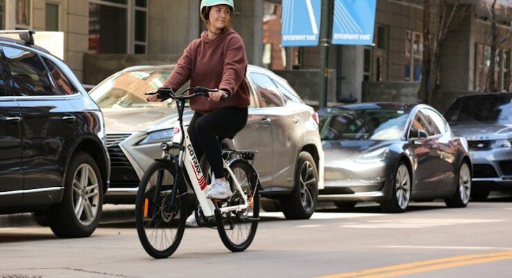 man in brown jacket riding on bicycle during daytime