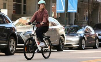 man in brown jacket riding on bicycle during daytime