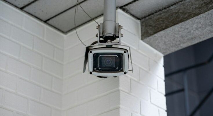 Security camera mounted on a white brick wall